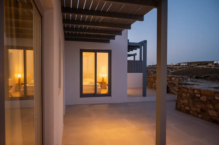 Spacious covered terrace with warm lighting and serene evening ambiance