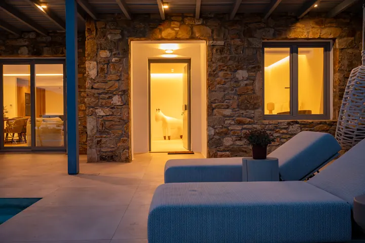 Warm stone terrace with cozy loungers and inviting indoor-outdoor ambiance