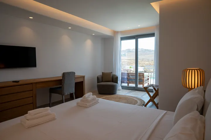 Bright modern bedroom with balcony seating and mountain views