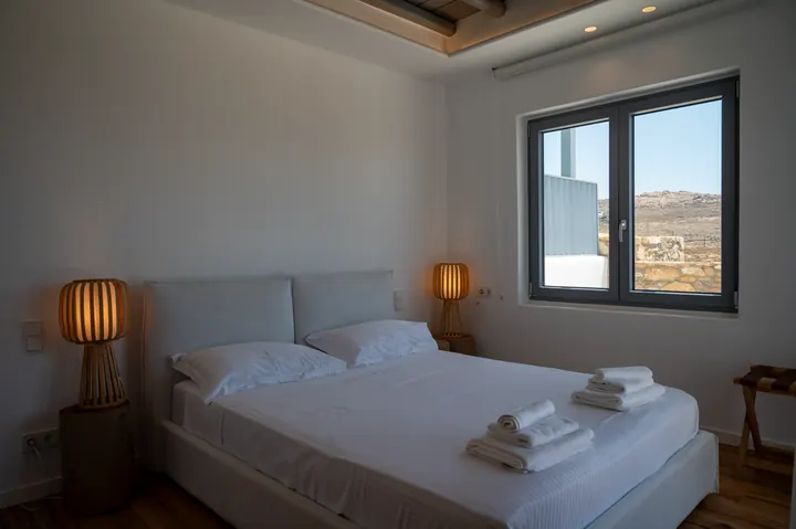 Serene modern bedroom with warm lighting and scenic window views