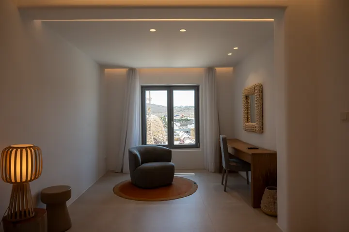 Bright, minimalist room with workspace and scenic hillside views