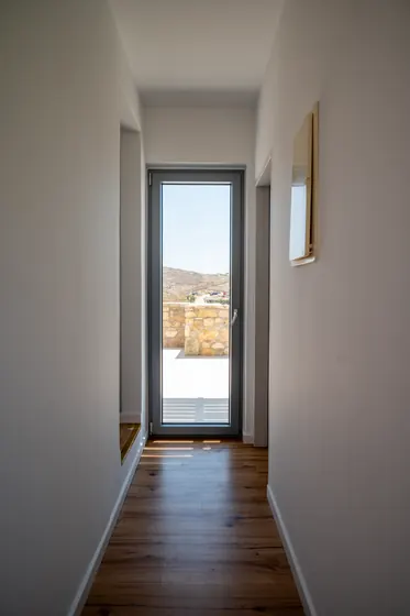 Bright hallway with wood floors and a glass door to scenic outdoor views