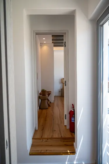 Bright minimalist hallway with warm wood floors and natural light