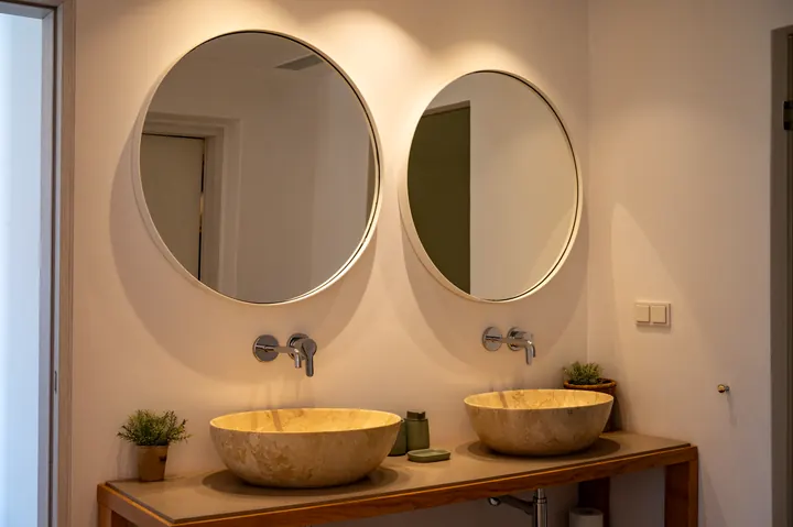 Elegant double vanity with round mirrors and warm modern styling