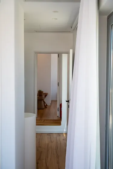 Bright minimalist hallway with natural light and warm wood floors