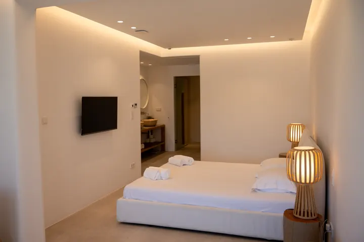 Minimalist ensuite bedroom with warm lighting and modern boutique style