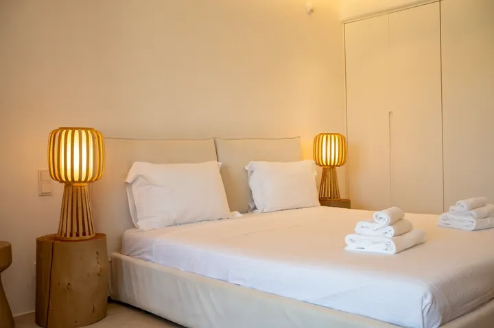 Minimalist bedroom with warm lighting and crisp hotel-style linens
