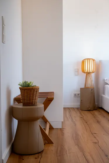 Warm minimalist bedroom corner with designer lighting and natural wood accents