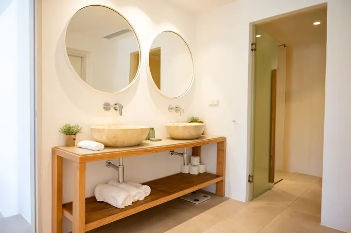 Spa-like bathroom with double vanity, stone sinks, and walk-in shower