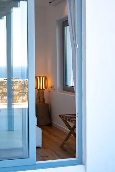 Bright bedroom nook with terrace access and warm coastal ambiance