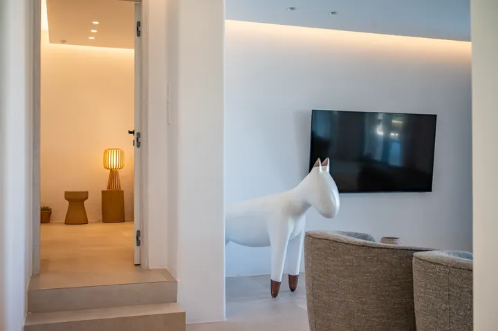 Stylish modern lounge with designer decor, warm lighting, and TV
