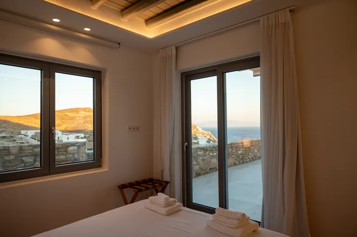 Serene bedroom with private terrace and stunning sea-view sunset light