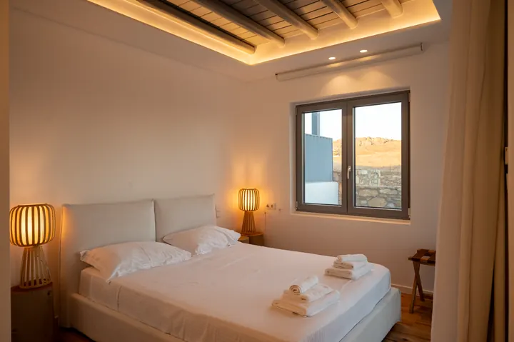 Cozy modern bedroom with warm lighting and scenic hillside views