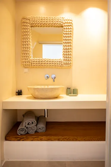 Spa-style bathroom vanity with stone sink and warm designer touches