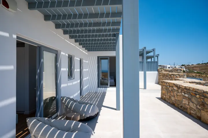 Sunny modern terrace with pergola shade and chic outdoor lounge seating