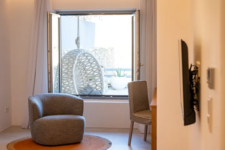 Bright modern room with balcony access and a chic hanging chair