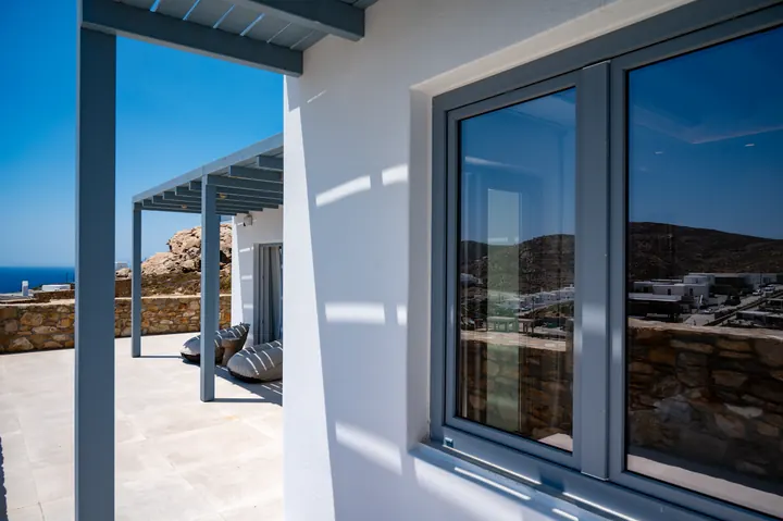 Modern shaded terrace with lounge seating and scenic hillside views