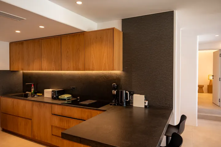 Stylish modern kitchenette with warm wood finishes and bar seating