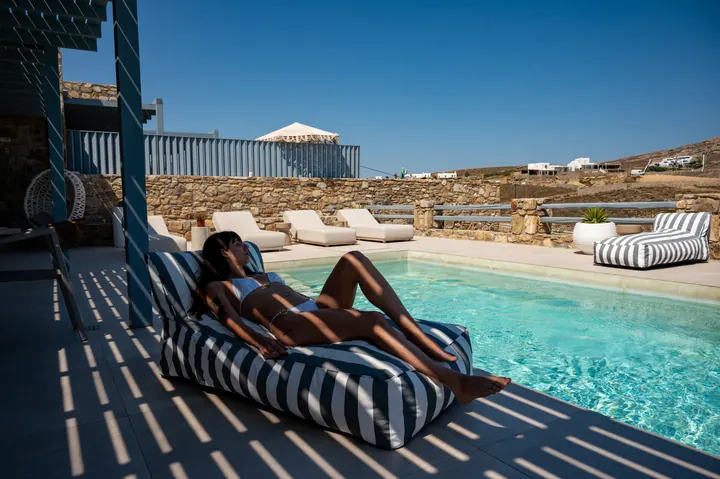 Private pool terrace with chic loungers and serene hillside views