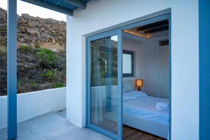 Modern bedroom with private terrace and serene hillside views