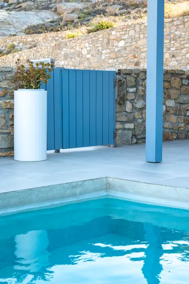 Modern poolside retreat with stone walls and serene blue design accents