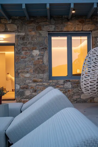 Cozy stone patio with plush seating and warm evening ambiance