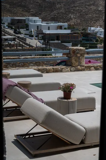 Chic sun terrace with plush loungers and scenic hillside views
