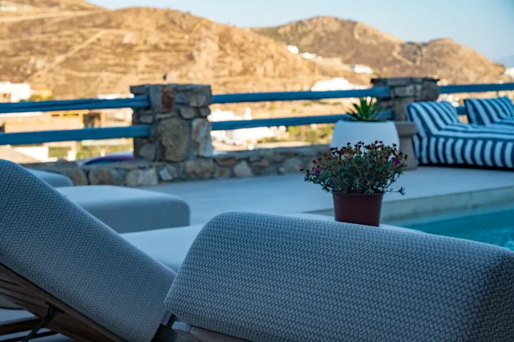Mountain-view pool terrace with chic loungers and serene outdoor seating