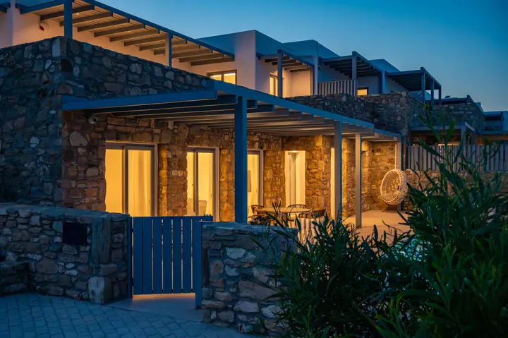 Elegant stone villa with cozy lit patio and modern outdoor living