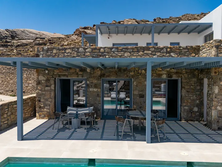 Stone villa with shaded terrace, outdoor dining, and private pool