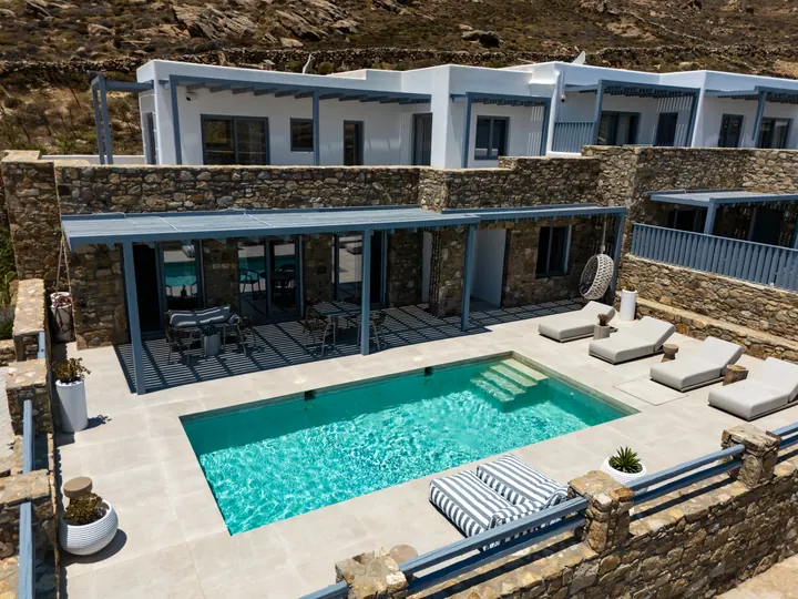 Private villa with sleek pool, sun loungers, and shaded outdoor lounge