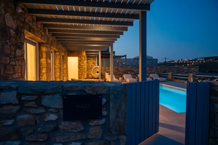 Stone villa terrace with glowing private pool at dusk