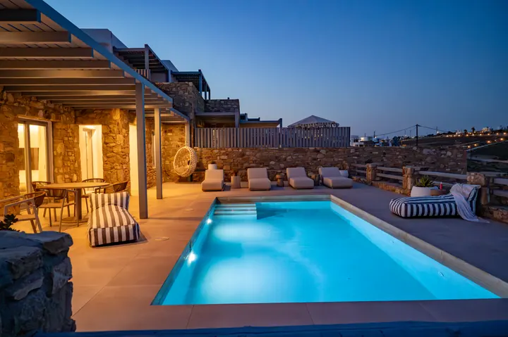 Private illuminated pool with sunset ambiance and chic outdoor lounge
